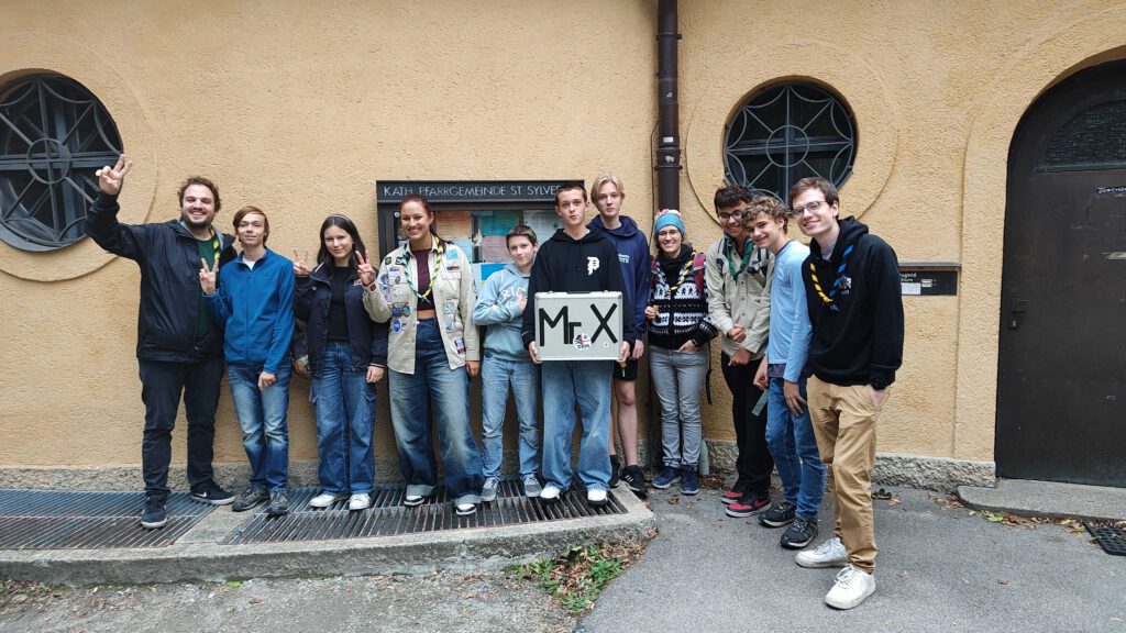 Gruppenbild vor dem Eingang zu den Jugendräumen von Swapingo mit dem Mister X Koffer.